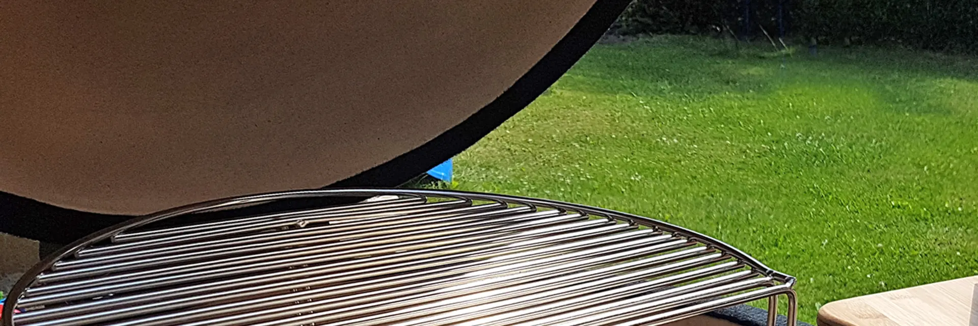 Geöffneter RedNeck Keramikgrill mit Edelstahlrost im Garten